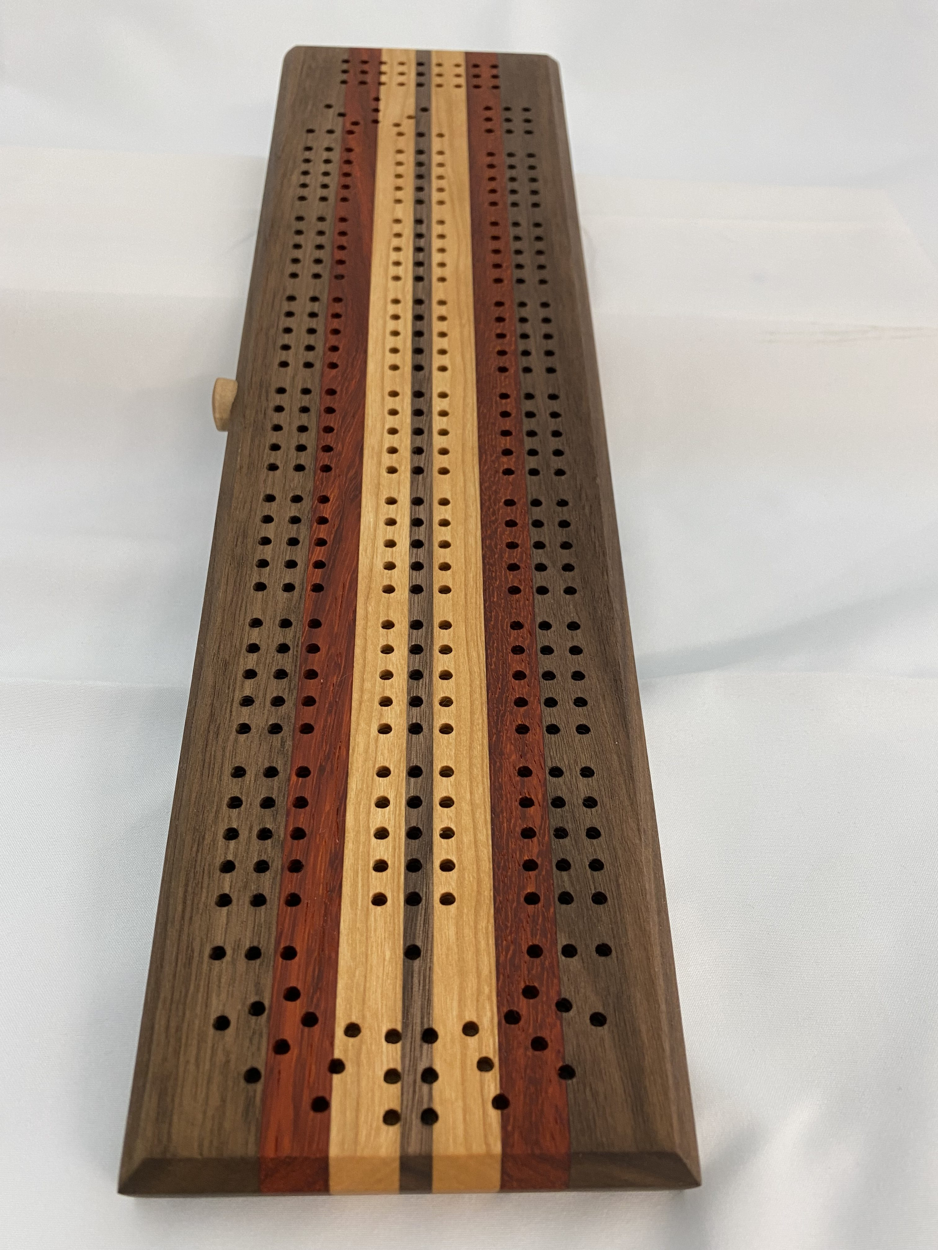 This cribbage board is made of Black walnut, padauk, and cherry.