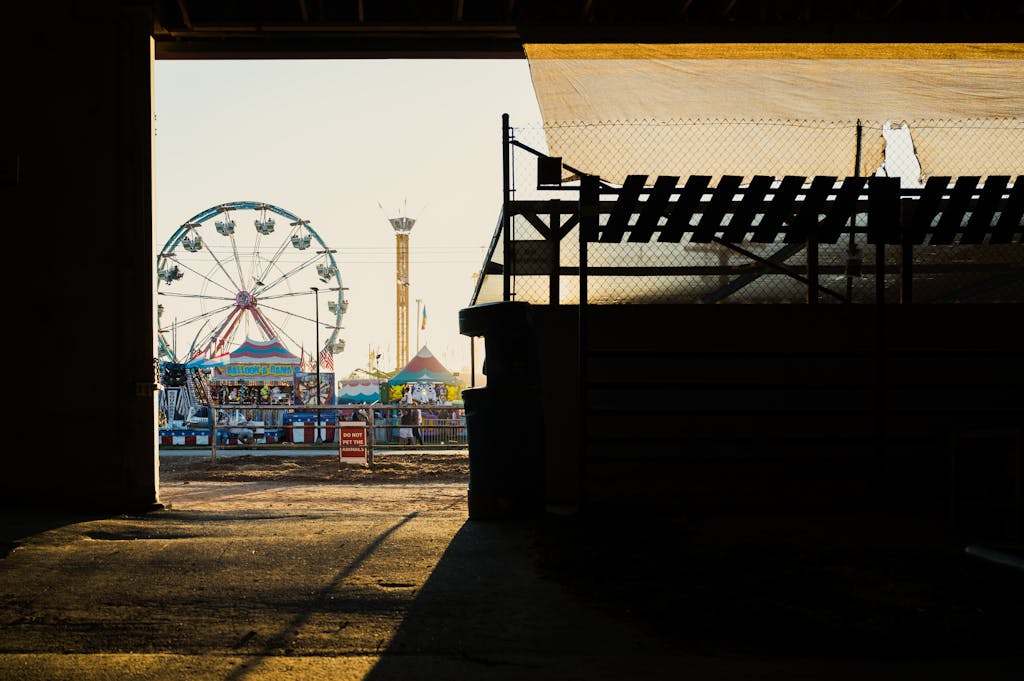A captivating view of a ferris wheel and fairground rides seen through a silhouette at sunset in Boise, Idaho.