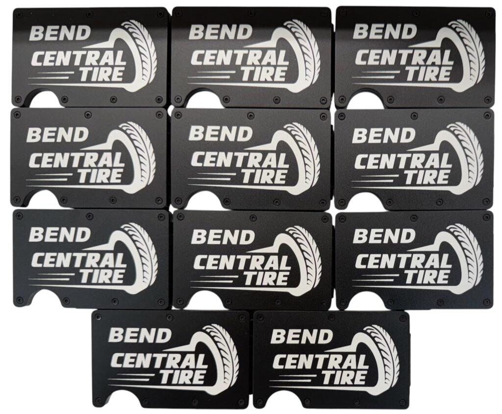 Bend Central Tire company logo laser engraved on a set of black metal wallets