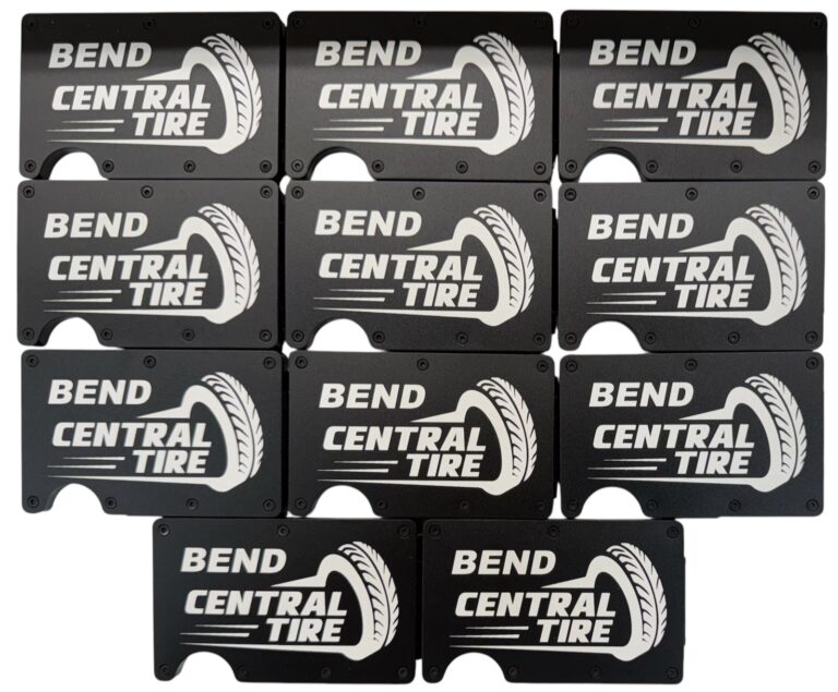Bend Central Tire company logo laser engraved on a set of black metal wallets