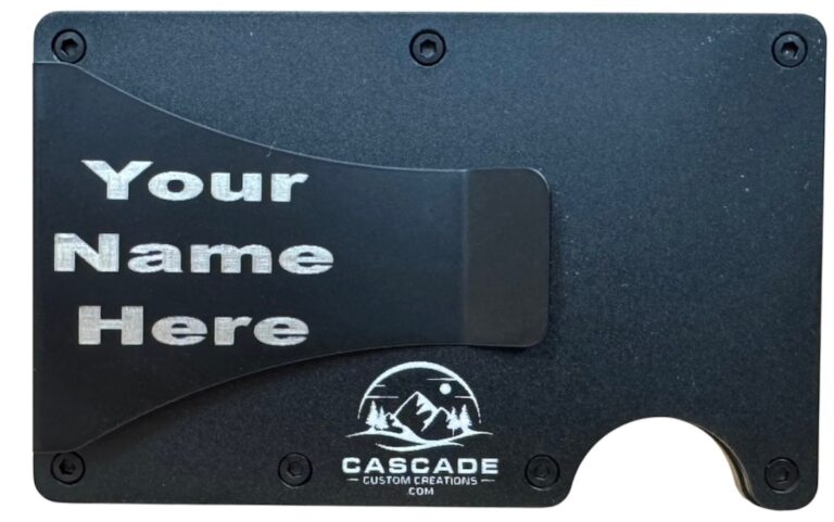 Back of a metal wallet showing a name laser engraved on the cash clip, to the left of the Cascade logo